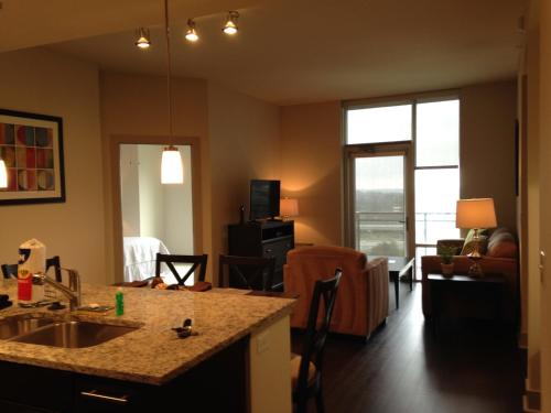 a kitchen with a sink and a living room at National at Tysons Corner in Howard