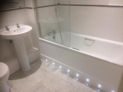 a bathroom with a tub and a sink and a toilet at Liverpool Apartments in Liverpool