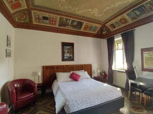 a bedroom with a bed and a chair and a desk at B&B Villa Ferrari in Asti