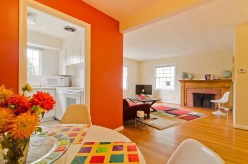 una sala de estar con paredes de color naranja y una mesa con flores. en Doyle Lovejoy, en Portland
