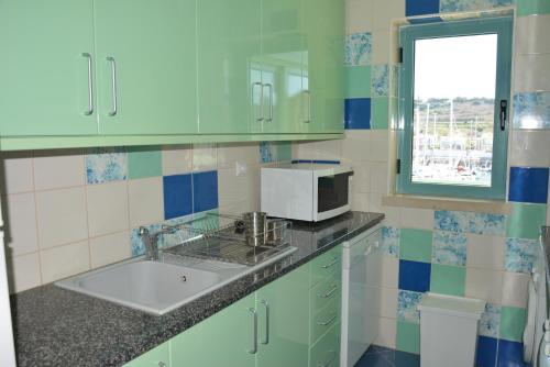 een keuken met een wastafel en een magnetron bij Beautiful Apartment In Albufeira Marina in Albufeira