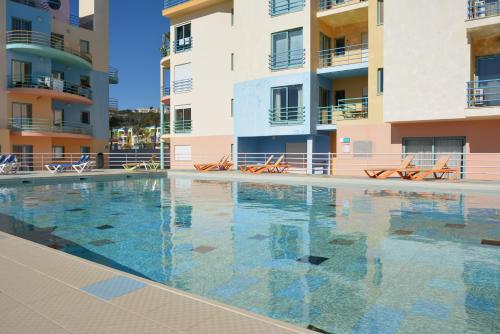 a swimming pool in front of some apartment buildings at Beautiful Apartment In Albufeira Marina in Albufeira
