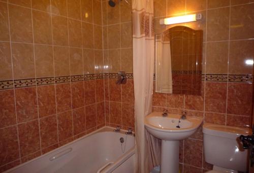 een badkamer met een wastafel, een toilet en een bad bij Fairfield Holiday Home No.13 in Dingle