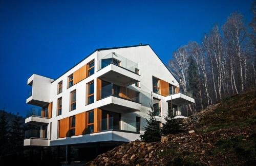 a white building on top of a hill at Apartamenty Willowa in Szczyrk