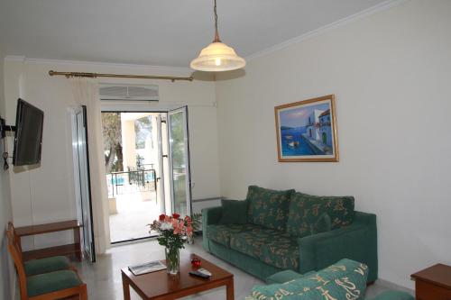 a living room with a green couch and a table at Saint Nicholas Beach Resort in Dassia