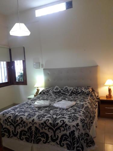 a bedroom with a bed with a black and white comforter at Departamento El Nogal in Alta Gracia