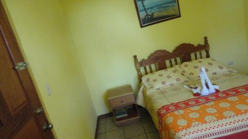 a bedroom with a bed with a stuffed animal on it at Hotel Santa Ana Liberia Airport in Liberia