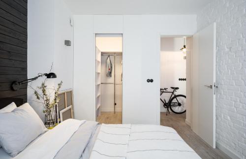華沙的住宿－Górska Apartament，白色卧室,设有白色砖墙