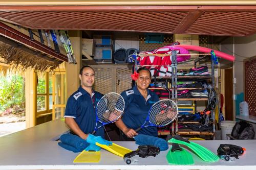 two people sitting on a table with tennis rackets at Sanctuary Rarotonga on the Beach (Adults Only) in Rarotonga