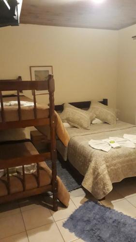 un dormitorio con una cama y una litera en Pousada Nonna Mimi, en Campos do Jordão