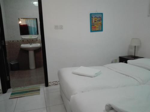 a bedroom with a bed and a bathroom with a sink at Salalah Beach Villas in Salalah