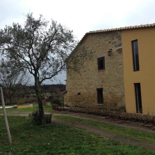 an old stone building with a tree next to it at Quinta Damigo in Seia
