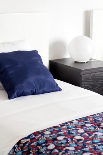 a bed with a blue pillow and a black nightstand at H18 in Horta