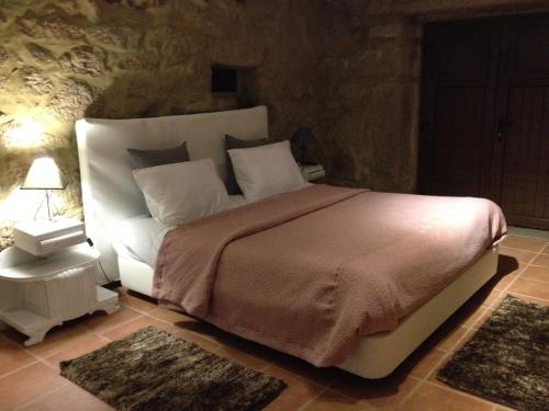 Un dormitorio con una cama grande y una mesa con una lámpara. en Quinta Damigo en Seia