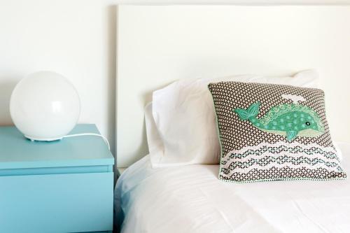 a bed with a pillow with a fish on it at H18 in Horta