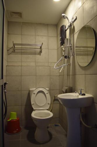 a bathroom with a toilet and a sink at Times Traveller Lodge 2 in Kota Belud