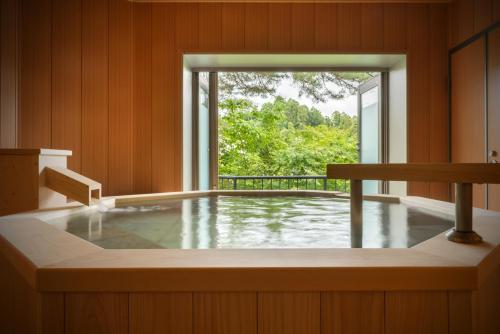 a jacuzzi tub in a room with a window at Shintomi-tei in Matsushima