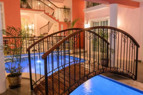 a metal bridge over a swimming pool in a house at Hotel Boutique Real San Juan Center in Mérida