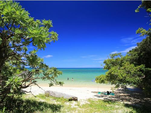 a beach with people swimming in the ocean at Seven Colors Ishigakijima in Ishigaki Island