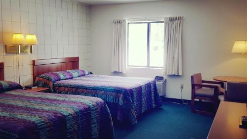 a hotel room with two beds and a window at Oakridge Motel in Newaygo