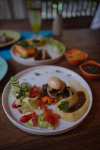 Un plato de comida con verduras en una mesa. en Rumah Batu Boutique Hotel, en Solo