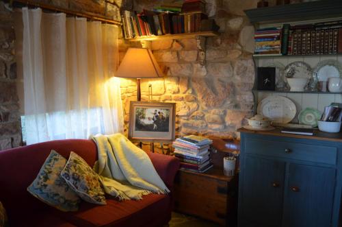 a living room with a red couch and a lamp at Trestrail Cottage Accommodation in Clare