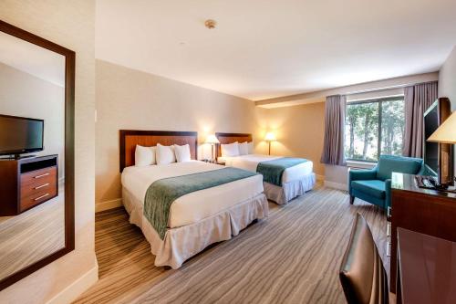 ein Hotelzimmer mit zwei Betten und einem Fernseher in der Unterkunft Heritage Hotel, Golf & Conference Center in Southbury