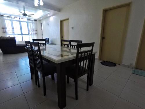 a dining room with a table and chairs in a room at Sultan Bridge Place in Kota Bharu
