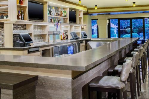 a bar with a long counter with bar stools at Hyatt Regency Westlake in Westlake Village