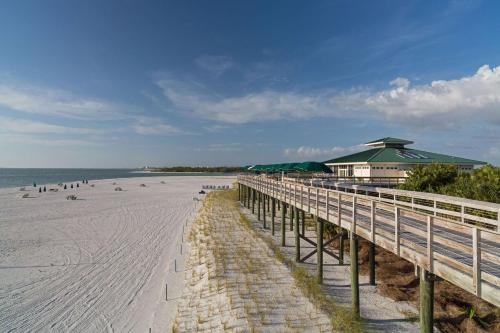 a beach with a pier and a building and the ocean at Hyatt Regency Coconut Point Resort & Spa Near Naples in Bonita Springs