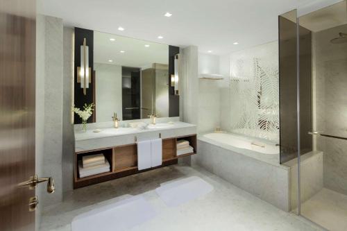 a bathroom with two sinks and a tub and a shower at Grand Hyatt Dubai in Dubai
