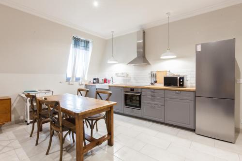 une cuisine avec une table, des chaises et un réfrigérateur dans l'établissement Appartement vue Mer, Suquet et Palais avec parking, à Cannes