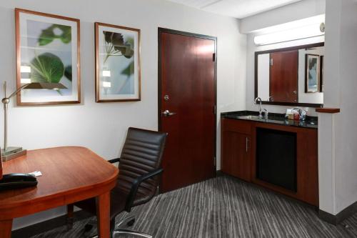 Cette chambre comprend un bureau, une table et une chaise. dans l'établissement Hyatt Place Sacramento Rancho Cordova, à Rancho Cordova