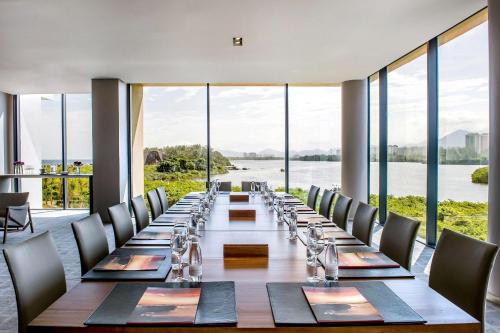a long table with chairs and a large room with windows at Grand Hyatt Rio de Janeiro in Rio de Janeiro