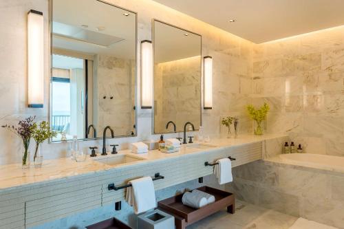 uma casa de banho com 2 lavatórios, uma banheira e um espelho. em Grand Hyatt Rio de Janeiro no Rio de Janeiro