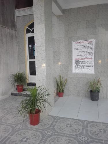 a building with potted plants in front of a window at Salalah Beach Villas in Salalah