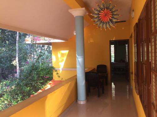 a hallway of a house with yellow walls and a table at Vaiga Home Stay in Kovalam
