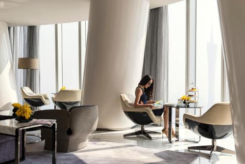 a woman sitting in a chair in a room at Four Seasons Hotel Guangzhou - Free Shuttle Bus to Canton Fair Complex & Overseas Buyer Registration Services during Canton Fair Period in Guangzhou