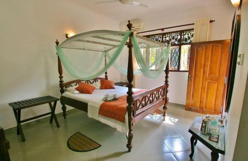 a bedroom with a bed with a canopy at Sagarika Beach Hotel in Moragalla