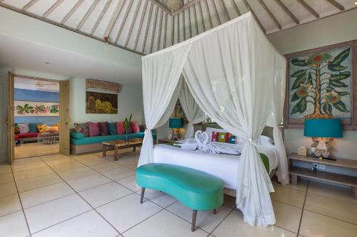 a bedroom with a white bed with a canopy at Villa Sky Li by Nagisa Bali in Seminyak