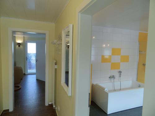 ein Badezimmer mit einer weißen Badewanne und einem Spiegel in der Unterkunft Sidowseetraum in Himmelpfort