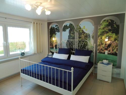 Schlafzimmer mit einem Bett mit blauen und weißen Kissen in der Unterkunft Sidowseetraum in Himmelpfort