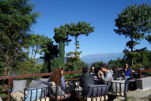 a group of people sitting on a bench at Hotel At The End Of The Universe in Nagarkot