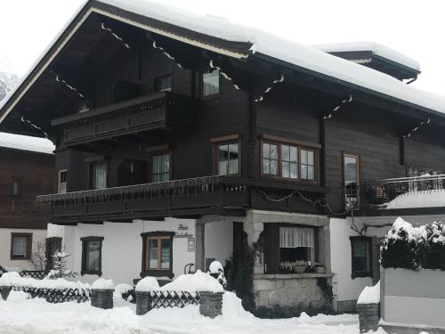 une maison recouverte de neige dans l'établissement Pension Kuntschner, à Mittersill