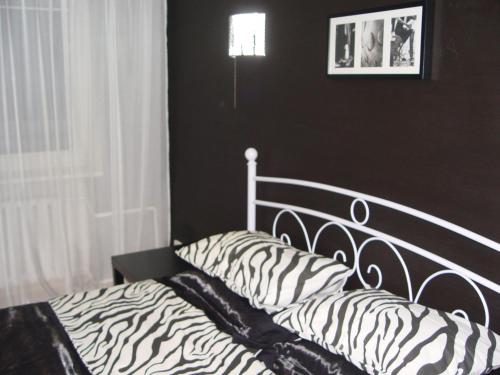 ein Bett mit Zebramuster in einem schwarz-weißen Schlafzimmer in der Unterkunft Apartment on Prospekt Masherova 26 in Brest