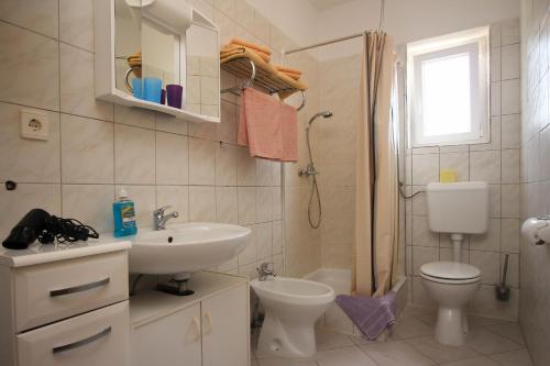 a bathroom with a sink and a toilet and a shower at Apartments Nikolic in Šilo