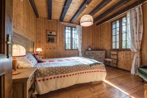 een slaapkamer met een bed, een bureau en ramen bij Chalet Silenthia in Ledro