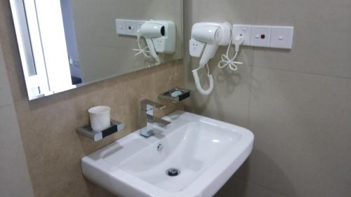 a bathroom with a white sink and a mirror at Lavendish Hills Kandy in Kandy