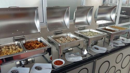 a buffet line with several trays of food at Lavendish Hills Kandy in Kandy