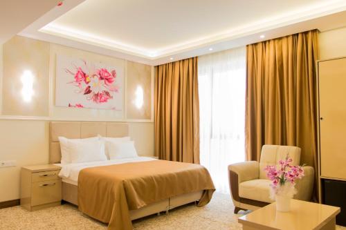 una camera d'albergo con letto e sedia di Goldhan Hotel a Tekirdağ